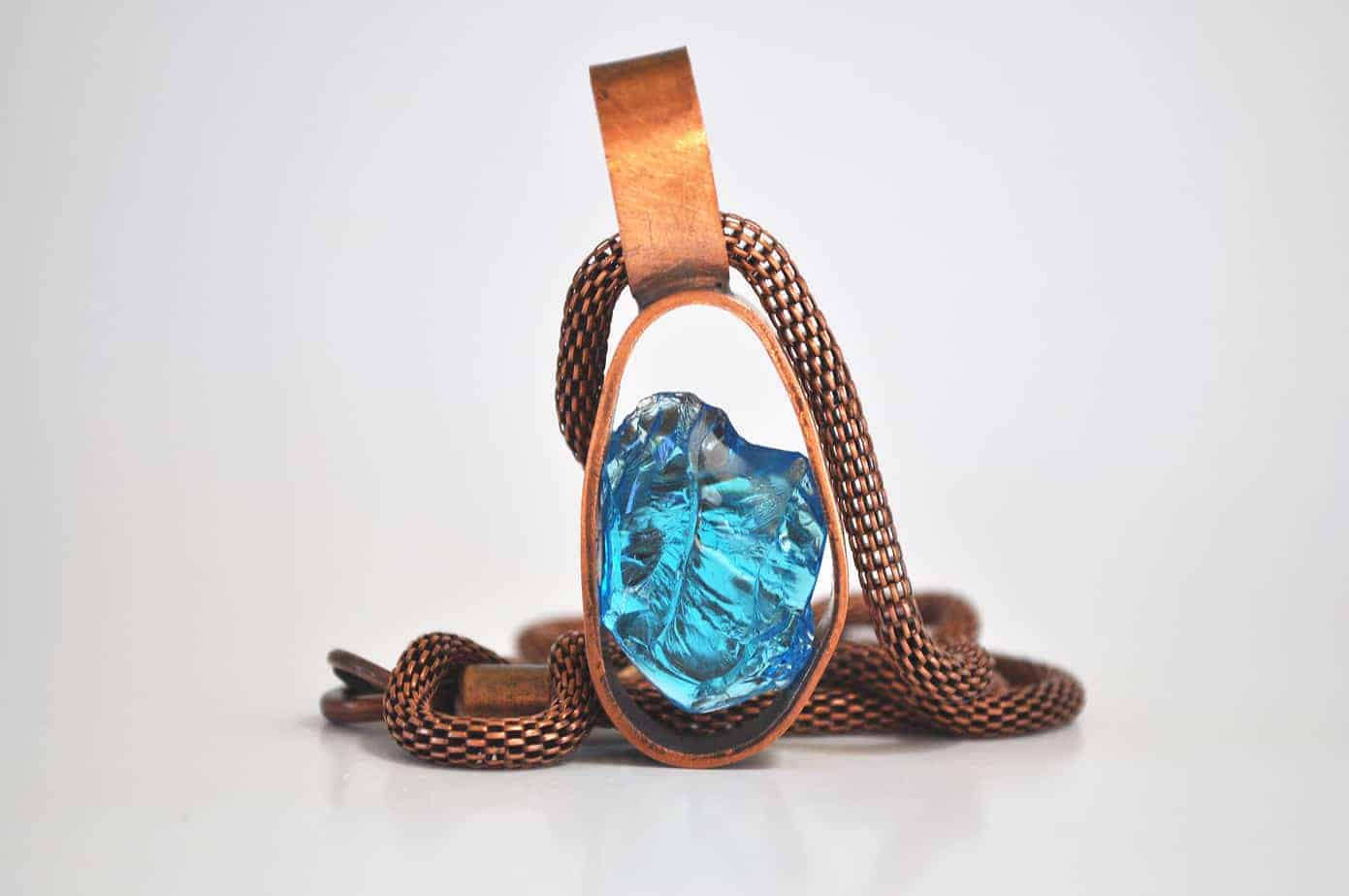 Necklace - glass crystal cullet suspended in copper tension setting on copper mesh chain.